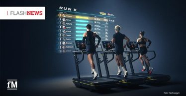 Im Vordergrund rechts laufen drei Personen von hinten auf drei Laufbändern mit Technogym-Logos. Auf dunklem Hintergrund links neben den Personen steht eine große digitale Rangliste mit der Überschrift „RUN X“, Positionen eins bis zehn, Namen Johnson, Rjones, Wjoung, Taylor, Wilson, Davies, Evans, Thomas, Robinson und Walker, Zeiten, farbigen Balken, Technogym-Logo und World Athletics-Logo. Oben links steht in einem weißen Rechteck „FLASHNEWS“, unten links das fM-Logo und unten rechts „Foto: Technogym“.