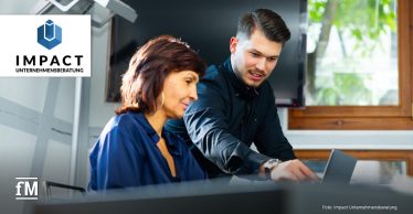 Eine Frau und ein Mann im Gespräch in einem modernen Büro.