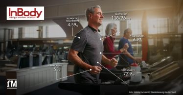 Eine Trainingssituation im Fitnessstudio, bei der Gesundheitsparameter wie Blutdruck, Muskelmasse, Handkraft und Körperfett visuell eingeblendet werden