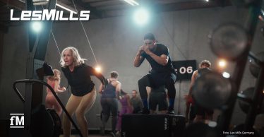 Mehrere Personen führen gemeinsam ein funktionelles Zirkeltraining mit verschiedenen Geräten in einem modernen Fitnessstudio durch.