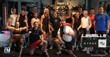 Gruppe von 15 Personen in Sportkleidung auf einer Trainingsfläche im HAUS OF HYROX