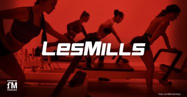 Vier Frauen trainieren auf Reformer-Geräten vor rotem Hintergrund mit LES-MILLS-Schriftzug