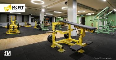 Trainingsfläche im McFIT Obergiesing mit gelben Kraftgeräten und hell ausgeleuchtetem Raum