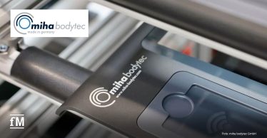 Nahaufnahme eines EMS-Geräts mit dem Logo von miha bodytec. Sichtbar sind ein Bedienfeld, ein Griff und Metallstreben im Hintergrund
