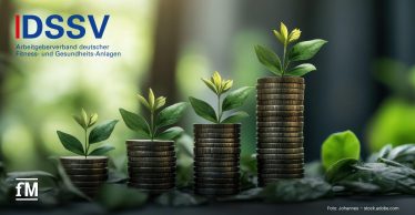 Vier unterschiedlich hohe Münzstapel mit wachsenden grünen Pflanzen symbolisieren finanzielle Entwicklung und Nachhaltigkeit. Links oben ist das Logo des DSSV – Arbeitgeberverband deutscher Fitness- und Gesundheits-Anlagen.