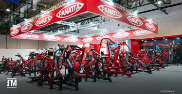 Auf dem Bild ist ein FIBO-Messestand mit zahlreichen roten Panatta-Fitnessgeräten zu sehen. Über den Geräten schwebt ein großes, rotes Schild mit dem weißen Logo „PANATTA“ auf rotem Grund.