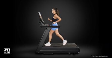 Frau läuft auf einem Precor Breakaway Laufband, seitliche Ansicht mit Konsole.