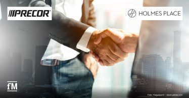 Zwei Personen in Businesskleidung geben sich im zentralen Vordergrund die Hand; links ein dunkler Anzugärmel, rechts ein heller Hemdsärmel. Im Hintergrund sind unscharfe Hochhausstrukturen und Firmenlogos von Precor und Holmes Place zu sehen.