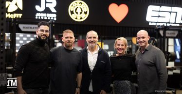 Fünf Personen (v. l. Ali Khadra, Philipp Markmann, Hagen Wingertszahn, Mary-Jo Slipek, Sascha Linz) stehen nebeneinander und lächeln in die Kamera. Sie befinden sich in einem Fitnessstudio. Im Hintergrund sind beleuchtete Logos der Marken McFIT, John Reed, Gold’s Gym, ein rotes Herzsymbol und das Logo von ESN in weißer Schrift auf schwarzem Grund zu sehen.
