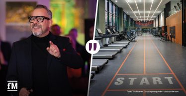 Mann im schwarzen Oberteil neben einer modernen Trainingsfläche mit Laufbändern.