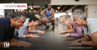 Ältere Menschen trainieren gemeinsam auf Matten in einem Fitnessstudio.