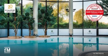Innenpool des MARE Wellness & Sport mit großen Fensterfronten und Jubiläumslogo.