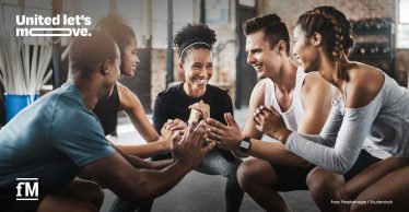 Fünf Personen sitzen in Sportkleidung im Kreis auf einer Trainingsfläche und klatschen in die Hände. Oben links der Schriftzug „United let’s move.“, unten links das Logo von „fM“, unten rechts der Bildnachweis PeopleImages/Shutterstock.