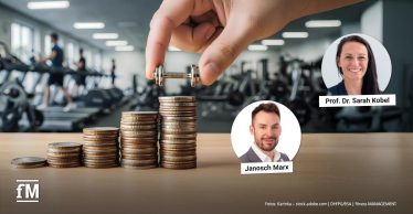 Eine Hand hält eine kleine Hantel über gestapelte Münzen auf einem Tisch. Im Hintergrund sind unscharf Fitnessgeräte und trainierende Personen zu erkennen.